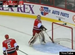 Hurricanes goalie Dan Ellis removes the puck from his net after Devils goalie Martin Brodeur scores on an empty net after an errant pass from Jordan Staal.