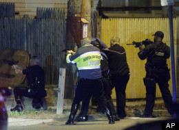 Police officers aim their weapons Friday, April 19, 2013, in Watertown, Mass. A tense night of police activity that left a university officer dead on campus just days after the Boston Marathon bombings and amid a hunt for two suspects caused officers to converge on a neighborhood outside Boston, where residents heard gunfire and explosions.(AP Photo/Matt Rourke)
