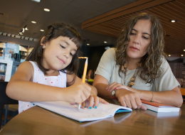 Roxana A. Soto (derecha), co-autora del libro 'Bilingual is Better', enseña a su hija Vanessa, de 6 años de edad, cómo escribir en español.