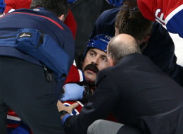 Montreal Canadiens right wing George Parros (15) is treated by medical staff after Parros hit his head on the ice during a fight with Toronto Maple Leafs right wing Colton Orr during third period National Hockey League action Tuesday, October 1, 2013 in Montreal.THE CANADIAN PRESS/Ryan Remiorz