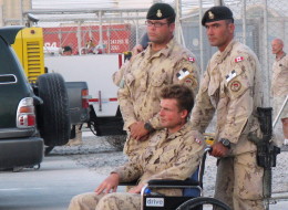 Pte. Glen Kirkland, in wheelchair, one of five soldiers injured in a direct fire explosion, attends a ramp ceremony for fallen comrades Cpl. Andrew Grenon, Cpl. Mike Seggie and Pte. Chad Horn, in Kandahar, Afghanistan, Thursday Sept. 4, 2008. Gravely injured troops who want to remain uniform are being booted from the military before they qualify for their pensions, despite assurances to the contrary from the Harper government. (THE CANADIAN PRESS/Tobi Cohen)