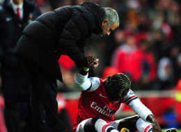 ose Mourinho manager of Chelsea helps Bacary Sagna of Arsenal to his feet during the Barclays Premier League match between Arsenal and Chelsea at Emirates Stadium on December 23, 2013 in London, England.