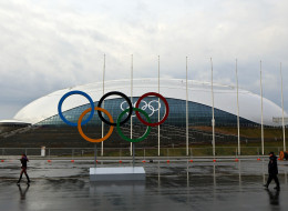 A woman and a police officer walk in front of Bolshoy Ice Dome in the Coastal Cluster on January 20, 2014 in Alder, Russia. (Photo by Michael Heiman/Getty Images)