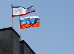 SIMFEROPOL, UKRAINE - MARCH 15:  Russian flag held is seen on the Crimean parliament building before the Crimean referendum in Simferopol on March 15, 2014. (Photo by Bulent Doruk/Anadolu Agency/Getty Images)