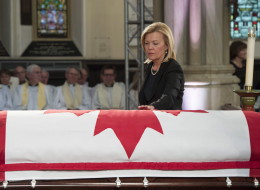 Christine Elliott touches the casket of her late husband at the state funeral for the Jim Flaherty in Toronto on Wednesday, April 16, 2014. THE CANADIAN PRESS/Frank Gunn