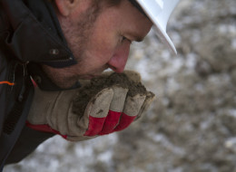 LAC-MEGANTIC, QUE - NOVEMBER 19: Jean Campagna, Urgent Environment Technician for the Province of Quebec, checks the smell of contaminated soil being stored just north of the Lac-Megantic train derailment site. Over 500,000 tonnes of soil is stored there over several specially made pads larger than a football field in 7 meter high mounds. November 19, 2013. (Chris So/Toronto Star via Getty Images)