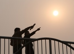 This picture taken on March 26, 2014 shows residents talking to each other on a bridge in Beijing as environmental authorities issued a 'yellow' smog alert for the capital. (STR/AFP/Getty Images)