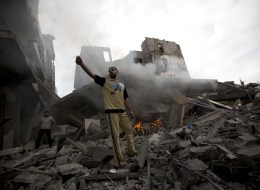 A Palestinian man reacts following an Israeli air strike in Gaza City on July 11, 2014. Israeli warplanes kept up deadly raids on Gaza but failed to stop Palestinian militants firing rockets across the border, as the United States offered to help negotiate a truce        (Photo credit should read MOHAMMED ABED/AFP/Getty Images)