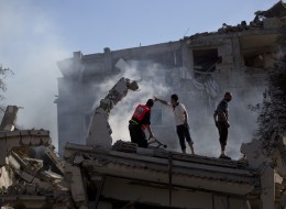Palestinian firefighters and residents try to extinguish fire at a house destroyed by an overnight Israeli air strike, on July 16, 2014, in Gaza City. New Israeli air and tank strikes in Gaza early today killed several people, medics said, bringing the death toll from Israel's operation in the besieged Palestinian territory to 204. AFP PHOTO / MAHMUD HAMS (Photo credit should read MAHMUD HAMS/AFP/Getty Images)