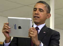 President Barack Obama looks at a classroom iPad in a seventh grade classroom before speaking about his ConnetED goal of connecting 99% of students to next generation broadband and wireless technology within five years, Tuesday, Feb. 4, 2014, at Buck Lodge Middle School in Adelphi, Md. (AP Photo/Jacquelyn Martin)
