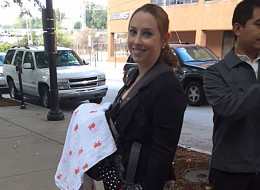 In this Oct 7, 2014 photo released by Stacy Ehrisman-Mickle, Ehrisman-Mickle poses for a photo with her daughter, in Atlanta. Ehrisman-Mickle, an immigration lawyer, brought her 4-week-old baby to court after Immigration Judge J. Dan Pelletier Sr. denied her request to delay a hearing that fell during her maternity leave. During the hearing, her baby began to cry, and Pelletier scolded her for inappropriate behavior. (AP Photo/Stacy Ehrisman-Mickle)