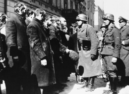 Nazi officers talk with citizens of the Warsaw ghetto, Poland, spring 1943.  (AP Photo)