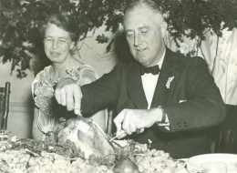 Eleanor Roosevelt watches as the President operates on the big turkey, setting in motion the annual Thanksgiving feast at Warm Springs, Georgia.November 29, 1935.