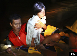 Rescuers carry a girl to safety after Philippine flash floods