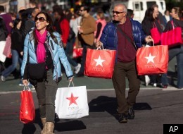 In this Nov. 25, 2011 file photo, consumers lug their bags through Herald Square during the first day of the holiday shopping season, Black Friday, in New York.