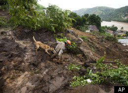 A firefighter takes a dog downhill at the site of a mudslide to search for missing people in Jamapara, Rio de Janeiro state, Brazil, Tuesday, Jan. 10, 2012. (AP)