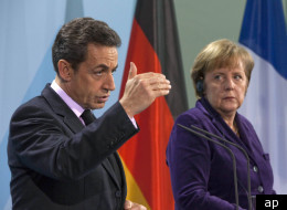 French President Nicolas Sarkozy with German Chancellor Angela Merkel. French officials have said they will implement cost-cutting measures in the wake of Friday's credit downgrade.
