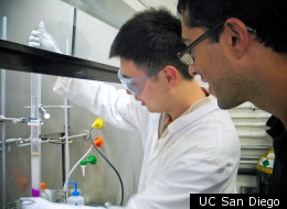 Neal Devaraj watches as undergraduate student Weilong Li works on a next step in their quest to create an entirely artificial cell.