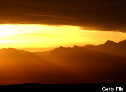 Sun rays illuminate the desert February 7, 2002 north of Las Vegas, NV where the primary proposed rail route for transporting radioactive waste to the site of Yucca Mountain lies. (Photo by David McNew/Getty Images)