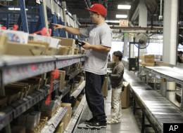 In this Wednesday, Nov. 16, 2011, photo, Dale Schlepp uses a scanner to check inventory during a break on the line that puts together orders for retail stores at the Nintendo of America Inc. distribution center in North Bend, Wash. U.S. workers increased their productivity over the summer by the most in a year and a half, but the gain was smaller than initially thought. (AP)