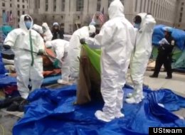 Work crews in white biohazard suits inspected tents in Freedom Plaza on Sunday afternoon. Some tents were found to be not in compliance and were dismantled.