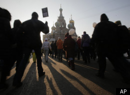 Demonstrators march during a massive protest against Prime Minister Vladimir Putin's rule in St. Petersburg, Russia, Saturday, Feb. 4, 2012, with the Savior of Spilled Blood Cathedral on the background. (AP)