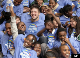 Denver Broncos quarterback Tim Tebow is surrounded by children as he visits the Boys & Girls Club in Los Angeles on Monday, Feb. 13, 2012. Tebow read a book, and encouraged children to read. (AP Photo/Nick Ut)