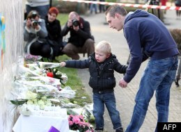 Un jeune belge apporte des fleurs mercredi à l'école des enfants tués en Suisse. (Photo AFP)