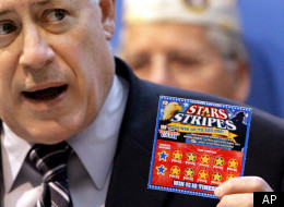 Illinois Gov. Pat Quinn shows off the Veteran's Cash scratch-off lottery ticket, the Stars & Stripes, in Springfield, Ill.
