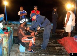 In this photo released by Ecuador's navy, Panamanian fisherman Adrian Vasquez, bottom left, an 18-year-old Panamanian who worked as a maid in a seaside resort hotel, receives medical attention aboard a fisherman boat offshore Galapagos Islands, Ecuador, on March 25. (AP Photo/Ecuador's navy)