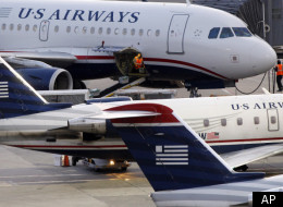 In this July 19, 2011 photo, baggage is unloaded from a U.S. Airways jet at Logan International Airport in Boston.