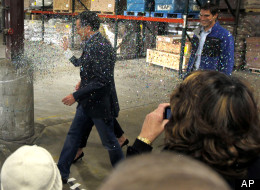A gay rights activist, not pictured, throws a cup of glitter on Republican presidential candidate, former Massachusetts Gov. Mitt Romney as he walks to the stage at the start of a campaign rally in Eagan, Minn., Wednesday, Feb. 1, 2012. (AP Photo/Gerald Herbert)