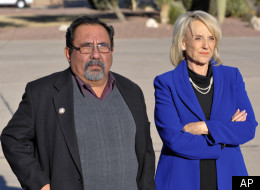 Arizona Gov. Jan Brewer (R) and Rep. Raul Grijalva (D-Ariz.) await the arrival of President Barack Obama on Jan. 12, 2011.