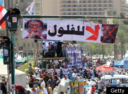 Egyptians sit on a traffic light decorated with a banner showing the portraits of former prime minister Ahmed Shafeq (R) and former Arab League general secretary Amr Mussa during a rally in Cairo's Tahrir Square on April 20, 2012, to protest against the ruling military and hold-overs from the former ruling government ahead of the presidential election to be held at the end of May. (KHALED DESOUKI/AFP/Getty Images)
