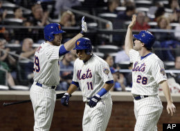 New York Mets' Ike Davis, left, celebrates with teammates Daniel Murphy (28) and Ruben Tejada (11) after they scored on a Scott Hairston double against the Arizona Diamondbacks, Friday, May 4, 2012, in New York.