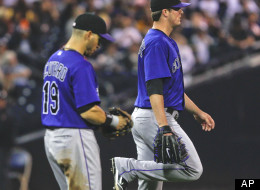 Colorado Rockies starting pitcher Drew Pomeranz flexes his right leg after being hit by a line drive from San Diego Padres batter Edinson Volquez during the second inning of a baseball game Monday, May 7, 2012 in San Diego. The Rockies' Marco Scutaro walks with Pomeranz. (AP Photo/Lenny Ignelzi)