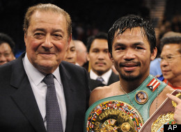 Manny Pacquiao, of the Philippines, center, holds his championship belt as he stands with promoter Bob Arum, left, and trainer Freddie Roach after winning his WBO welterweight boxing title fight against Miguel Cotto, Saturday, Nov. 14, 2009.