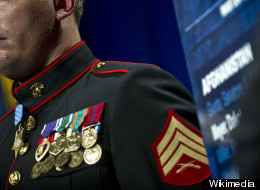 A U.S. Navy Medal of Honor recipient stands at attention while his award citation is read. (Wikimedia)