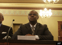 Illinois Rep. Derrick Smith, D-Chicago, listens to fellow lawmakers while attending a legislative committee hearing investigating whether Smith should be disciplined over a bribery charge at the Illinois State Capitol Thursday, May 10, 2012 in Springfield, Ill. Smith refused to answer the legislative panel's questions, but he insisted he is innocent. (AP Photo/Seth Perlman)