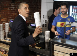 President Barack Obama holds up his hoagie sandwich that he purchased from David Mazza, right, co-owner of Taylor Gourmet during his visit to the local small business in the U Street neighborhood in Washington, Wednesday, May 16, 2012. Also behind the counter is Casey Patten, co-owner. (AP Photo/Pablo Martinez Monsivais)
