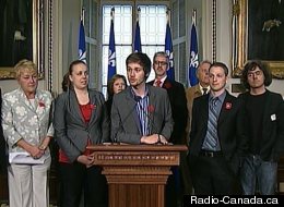 Léo Bureau-Blouin, au micro, accompagné par Martine Desjardins (à sa gauche), d'élus et de représentants des carrés verts et blancs. (Radio-Canada.ca)