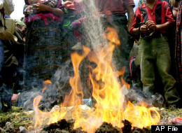 A Mayan priest thows sugar to the fire during a Mayan ceremony to commemorate the anniversary of a 1982 massacre of 184 people carried by the Guatemalan army during the regime of former dictator Efrain Rios Montt in Plan de Sanchez, a small village 200 km (125 miles) north of Guatemala City, Monday, July 19, 2004. (AP Photo/Rodrigo Abd)