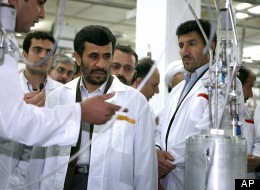 Iranian President Mahmoud Ahmadinejad (center) listens to a technician during a visit to the Natanz Uranium Enrichment Facility.