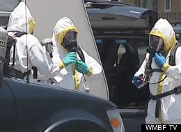Officials in Hazmat suits clear the motel room of hazardous materials from the meth lab.