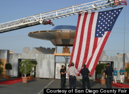 A real American flag is hoisted up next to a fake flying saucer at the San Diego County Fair, which is focused around a UFO theme this year. The Fair runs through July 4.