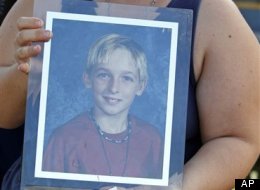 FILE - In this Wednesday, Oct. 14, 2009 file photo, Malissa Durkee holds a framed photo of her brother Michael Brewer as she talks to a reporter in Deerfield Beach, Fla. Five teenagers were charged with aggravated battery for dousing the 15-year-old Brewer with rubbing alcohol and setting him on fire because he stopped someone from stealing his father's bicycle, authorities said. Michael Brewer was hospitalized with burns on more than three-quarters of his body after the attack at a Deerfield Be