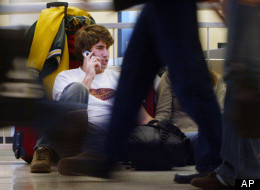 Matt Mason from Tampa, Fla., talks on his cell phone as he waits for a ride to his girlfiend's grandparents home in Franklin Park, Ill., at Midway Airport in Chicago, Wednesday, Nov. 23, 2005. (AP Photo/Charles Rex Arbogast)