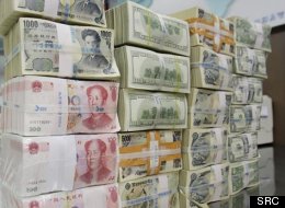 Un employé d'une banque en Corée du Sud près d'une pile de billets en devises étrangères (archives) © PC/AP/Lee Jin-man