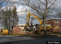 A bulldozer demolishes a home in Mount Holly Gardens, N.J.