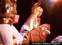 A man riding a giant chicken sprinkled glitter on contestants.